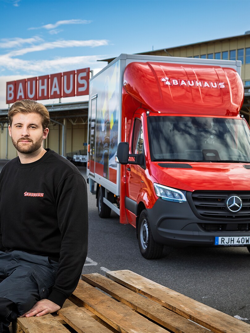En anställd från Bauhaus med en Mercedes-Benz eSprinter i bakgrunden