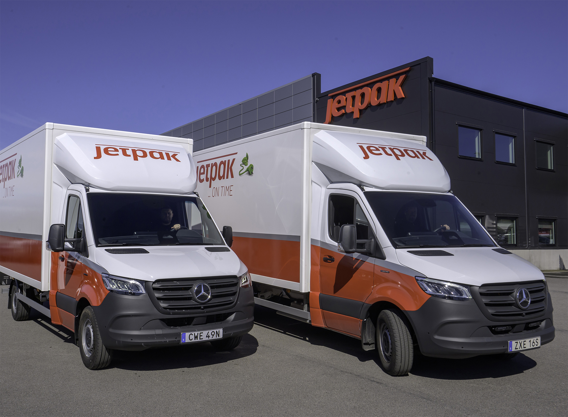 C.G. Erikssons Åkeri | Företag och kunder | Mercedes-Benz Transportbilar Person står framför två vita Mercedes-Benz eSprinter från Jetpak