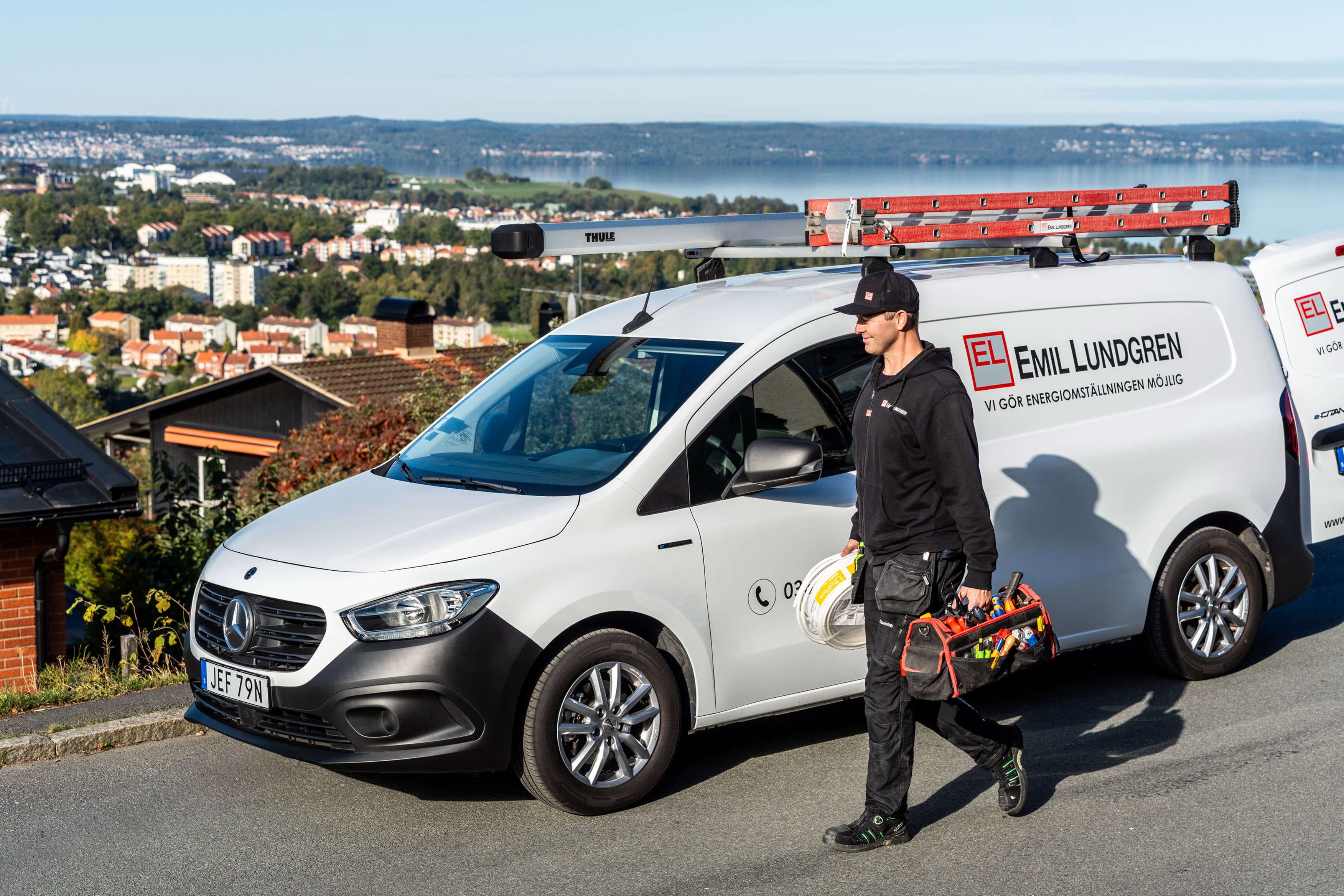 Leasa helelektriska eCitan | Mercedes-Benz Transportbilar Eltekniker med utrustning i händerna står framför sin Mercedes-Benz transportbil.