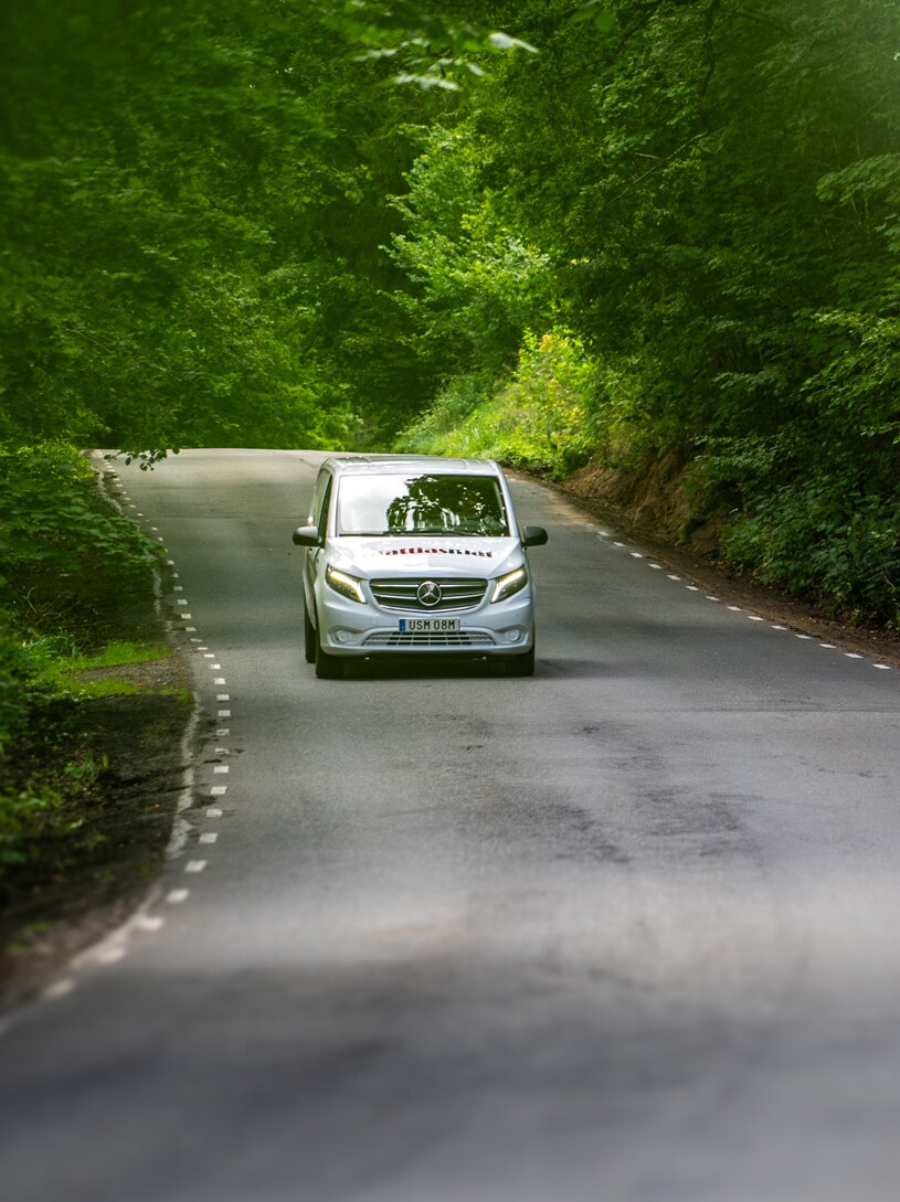 En Mercedes-Benz eVito körandes på landsväg med skog i bakgrunden