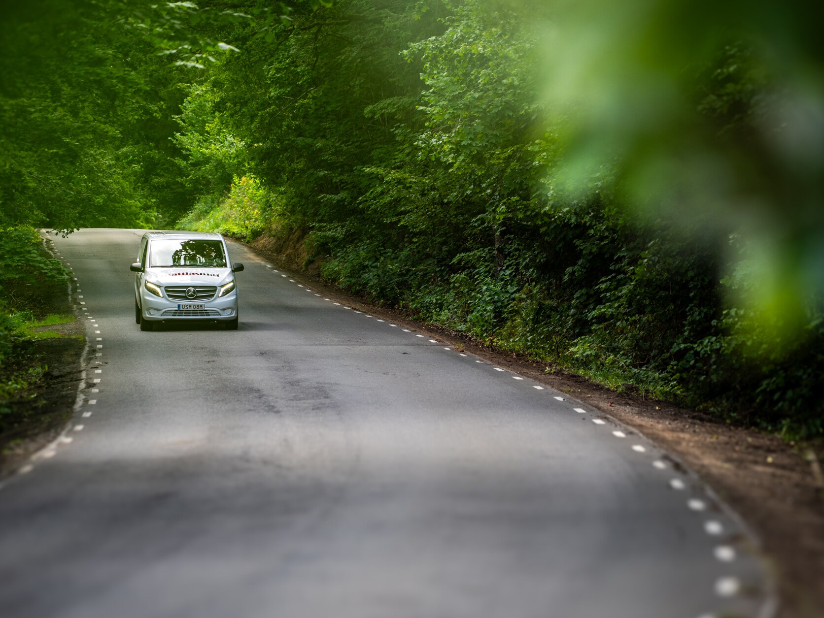 En Mercedes-Benz eVito körandes på landsväg med skog i bakgrunden