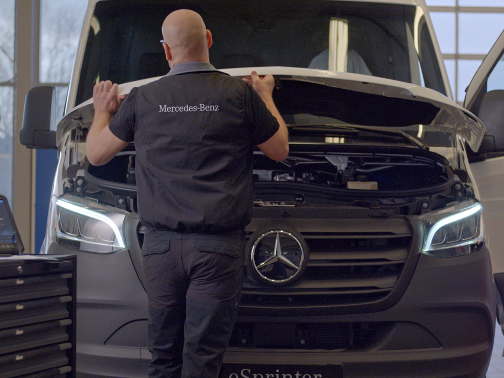 Servicetekniker öppnar huven på en Mercedes-Benz eSprinter