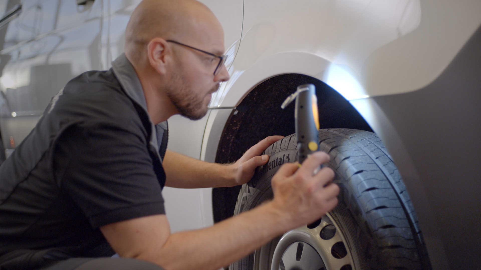 Däckförvaring | Orginalhjul | Mercedes-Benz Transportbilar Mercedes-Benz-medarbetare monterar ett nytt däck på en skåpbil.