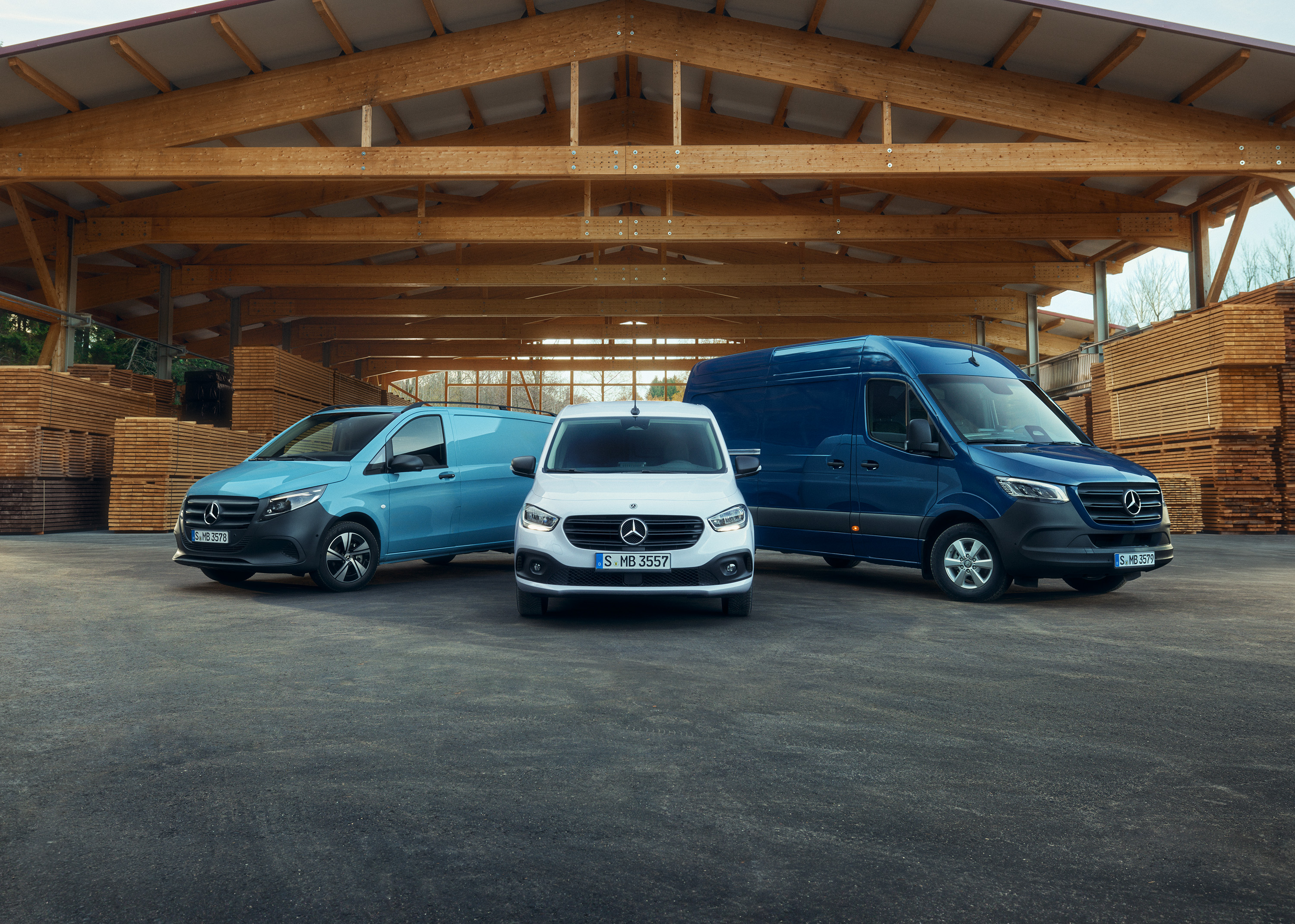 Transportbilar | Mercedes-Benz Transportbilar Tre transportbilar från Mercedes-Benz som står bredvid varandra på en brädgård