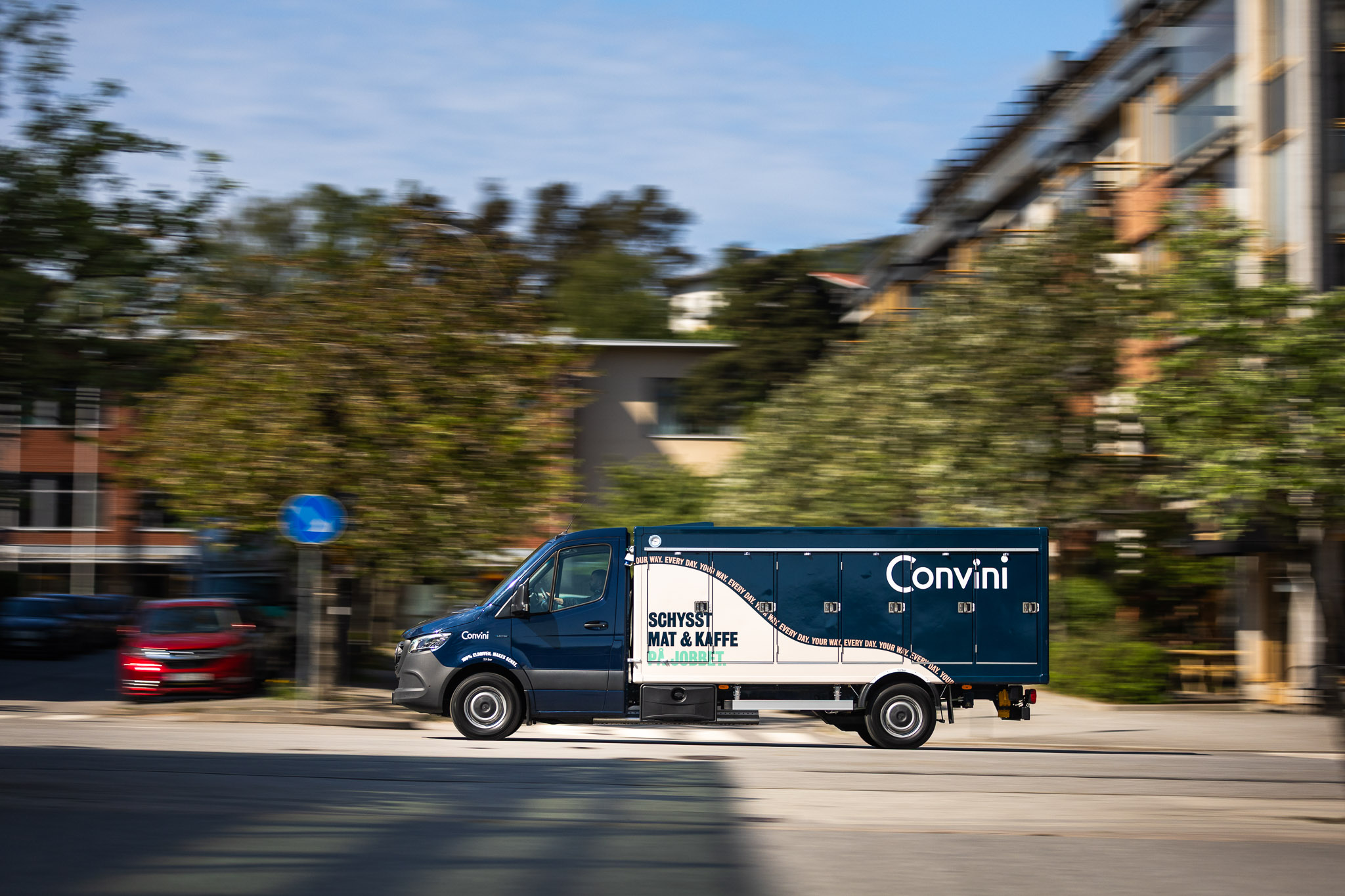 Convini | Företag och kunder | Mercedes-Benz Transportbilar Blå ombyggd eSprinter från Mercedes-Benz körandes i en storstad.
