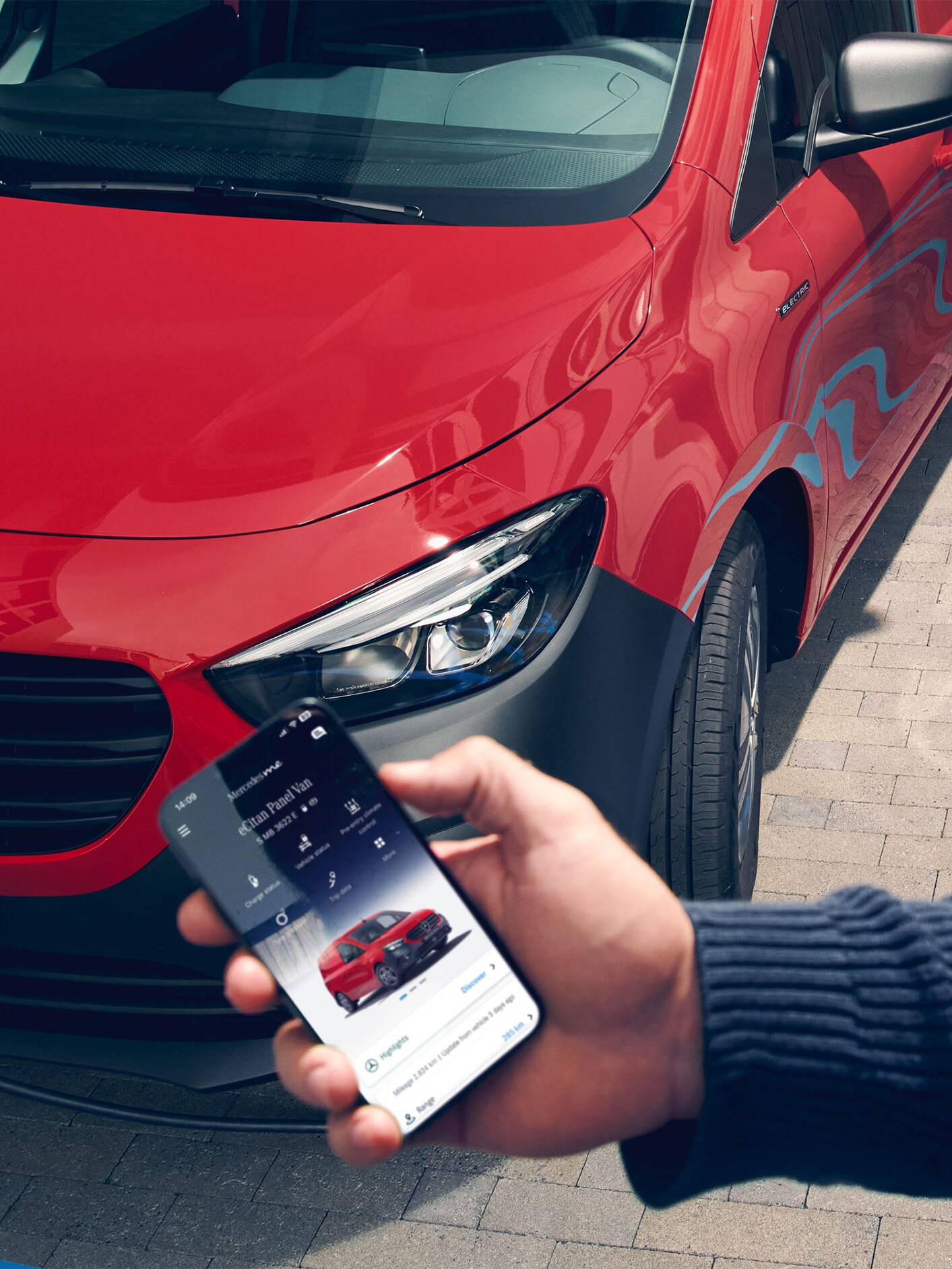 Person använder Mercedes-Benz app för att kolla status på sin röda transportbil