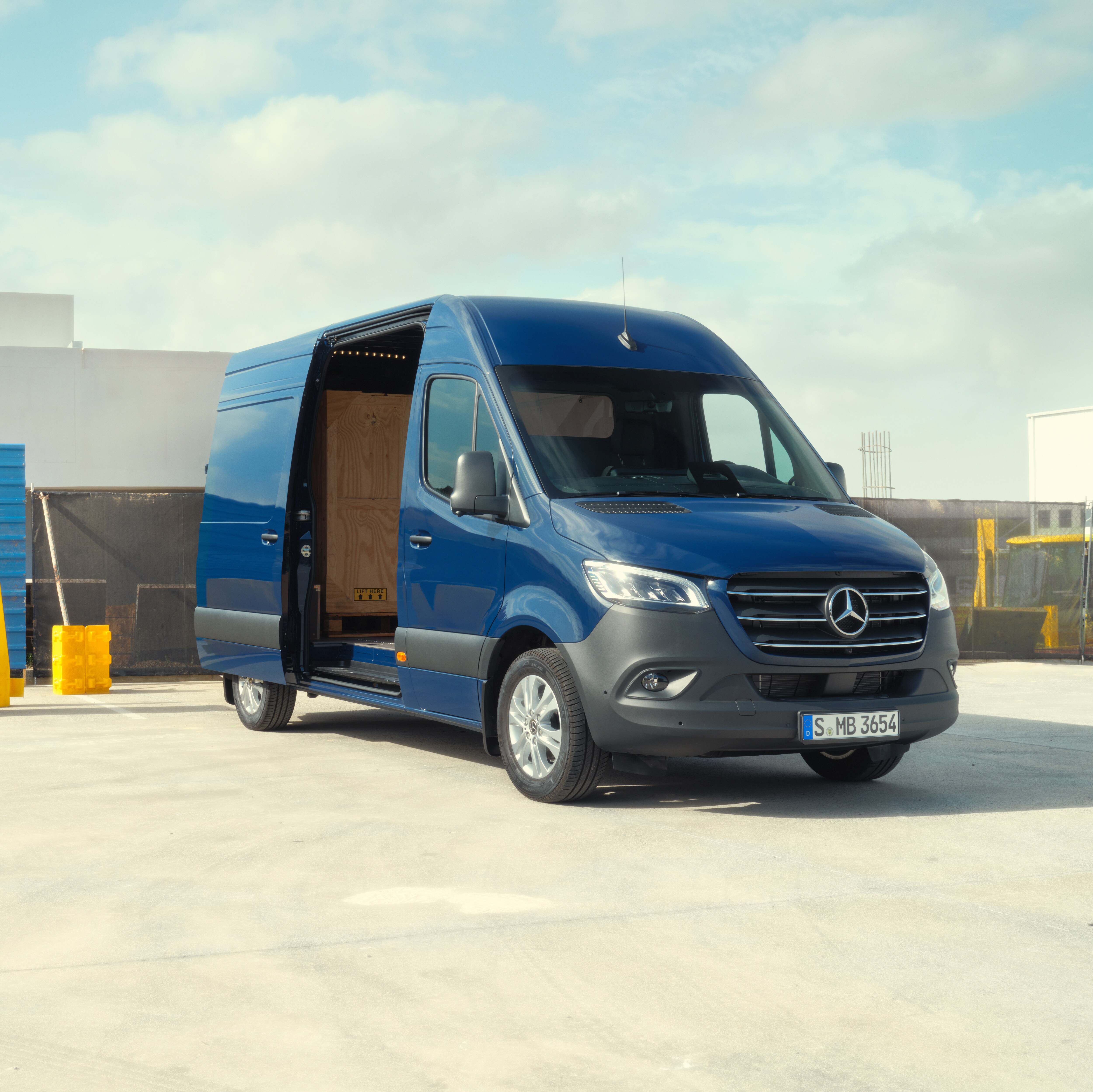 Mercedes-Benz transportbil med öppen skjutdörr parkerad på taket av en byggnad