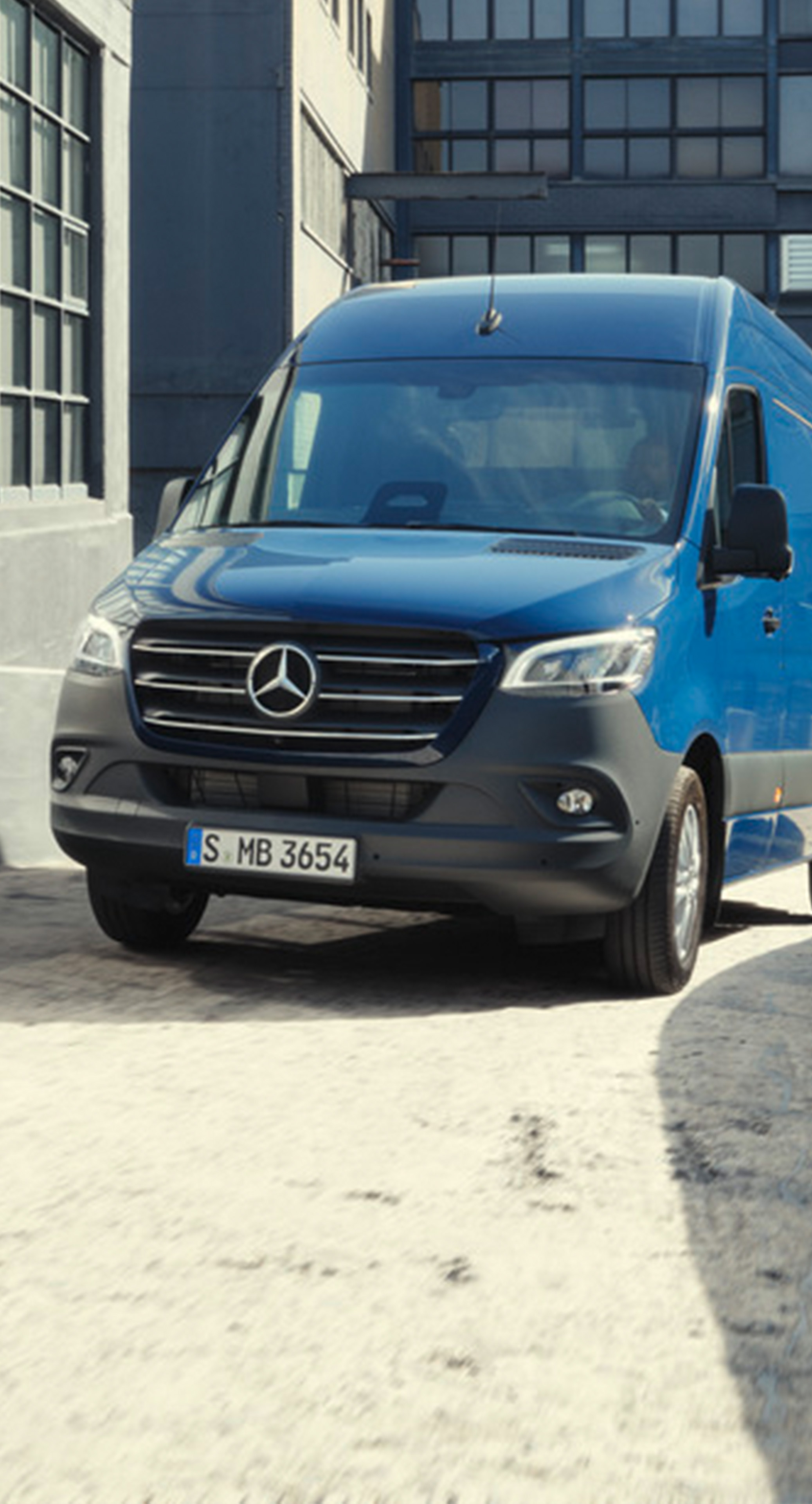 Mörkblå Mercedes-Benz Sprinter Skåpbil navigerar på byggarbetsplats