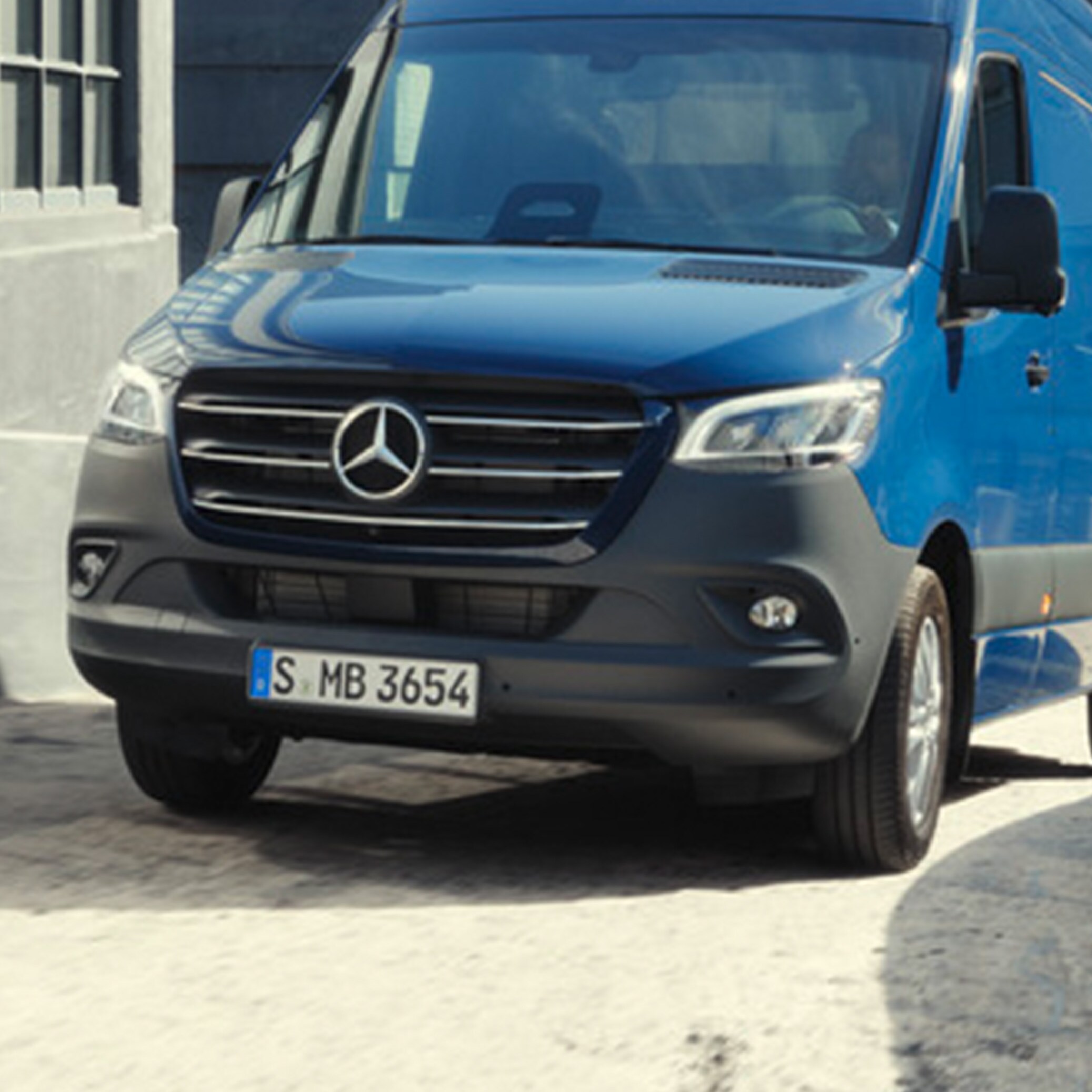 Mörkblå Mercedes-Benz Sprinter Skåpbil navigerar på byggarbetsplats