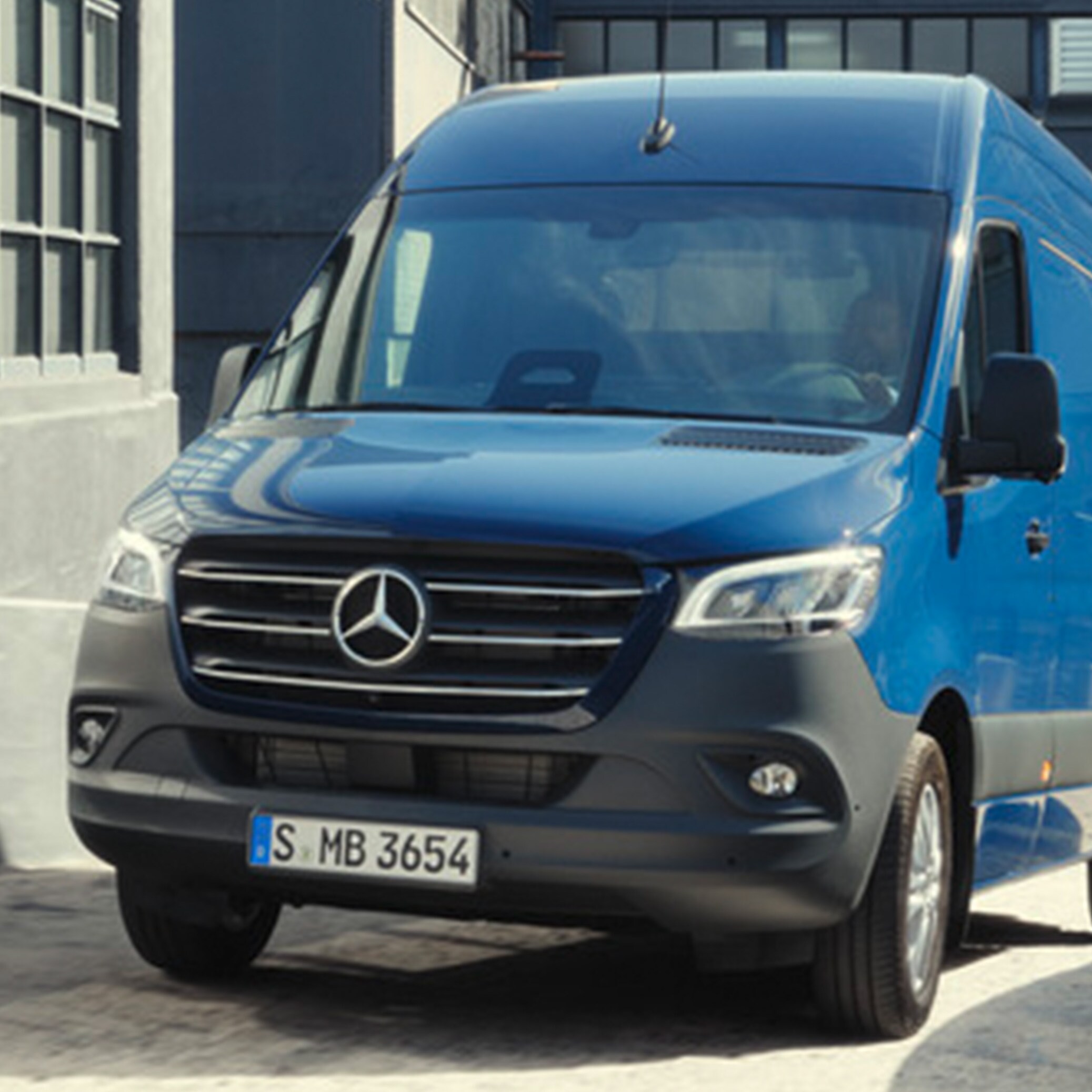 Mörkblå Mercedes-Benz Sprinter Skåpbil navigerar på byggarbetsplats