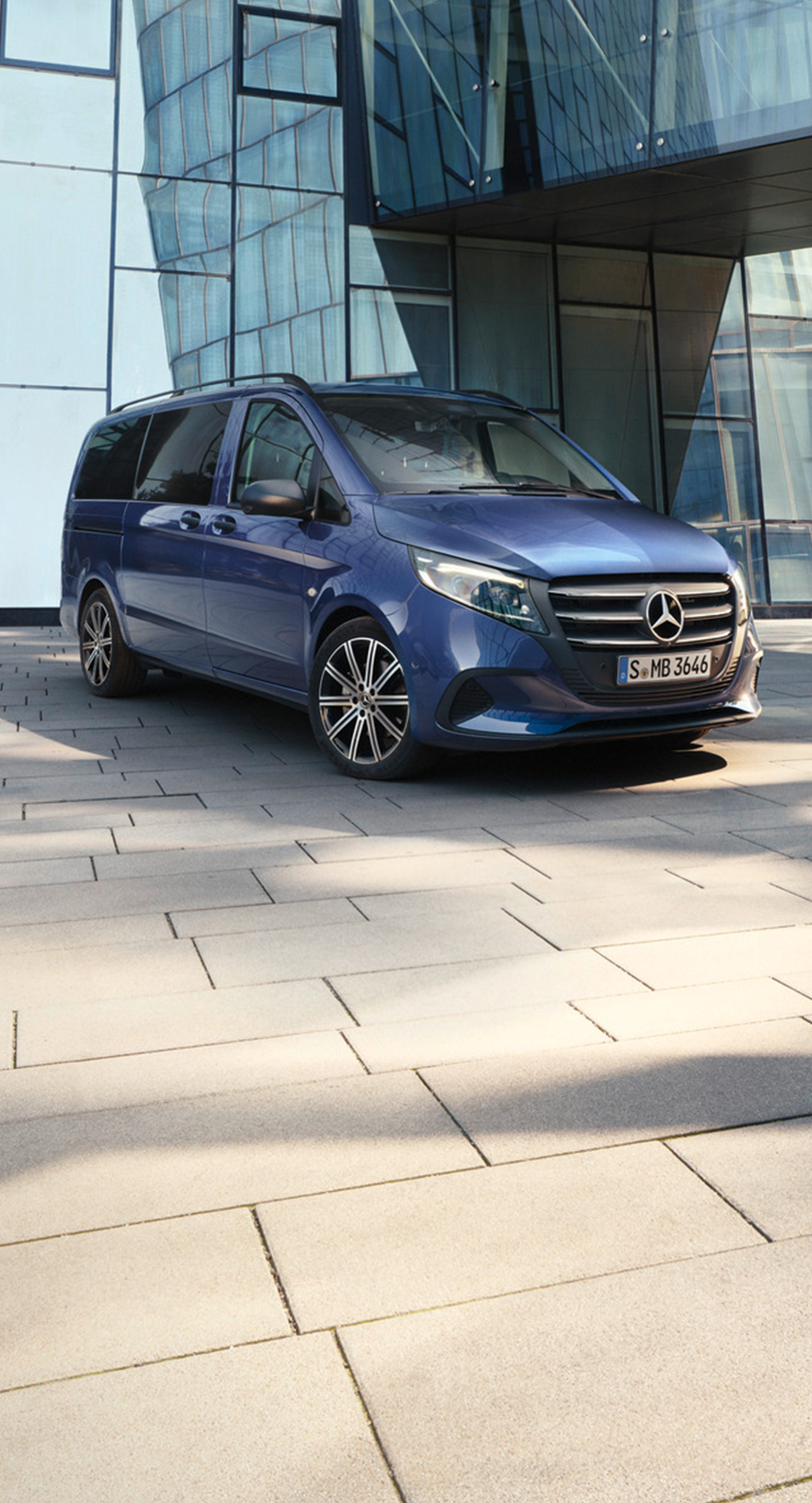 Metallic mörkblå Vito Tourer parkerad vid byggnad med glasfasad