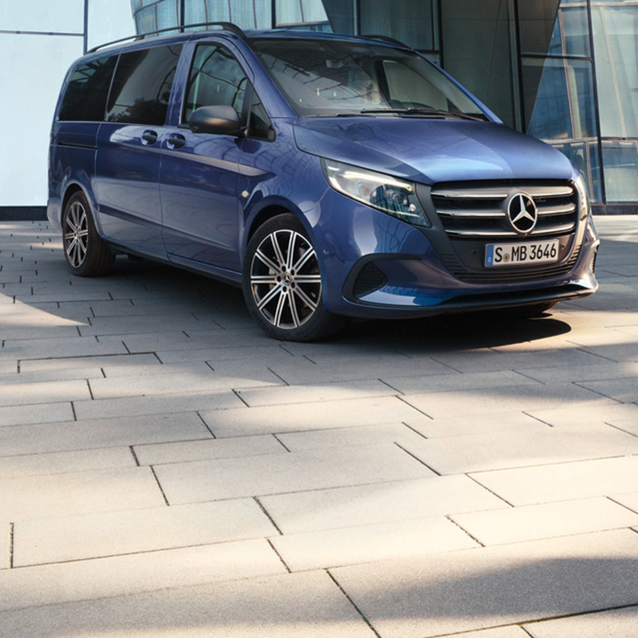Metallic mörkblå Vito Tourer parkerad vid byggnad med glasfasad
