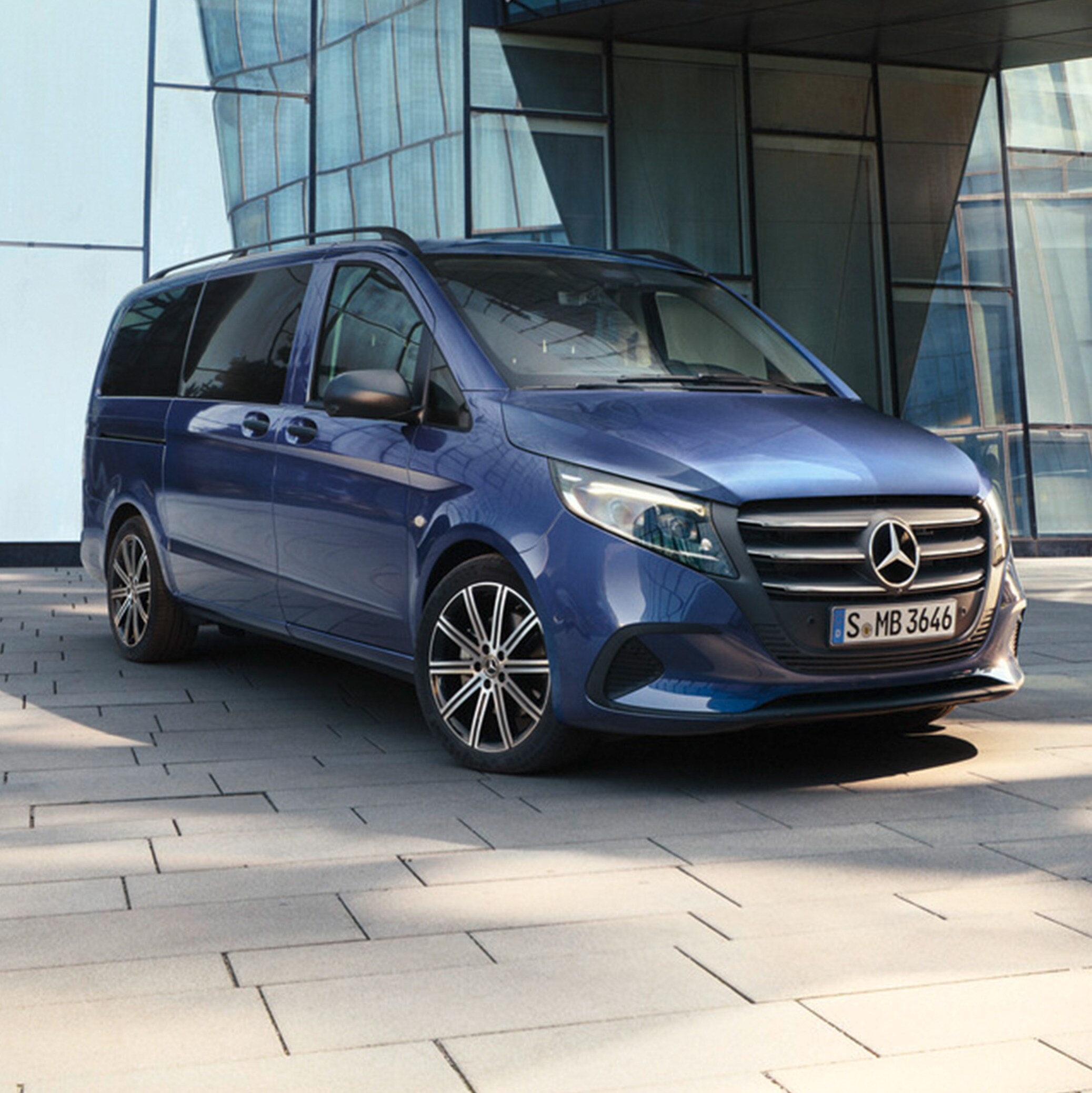 Metallic mörkblå Vito Tourer parkerad vid byggnad med glasfasad