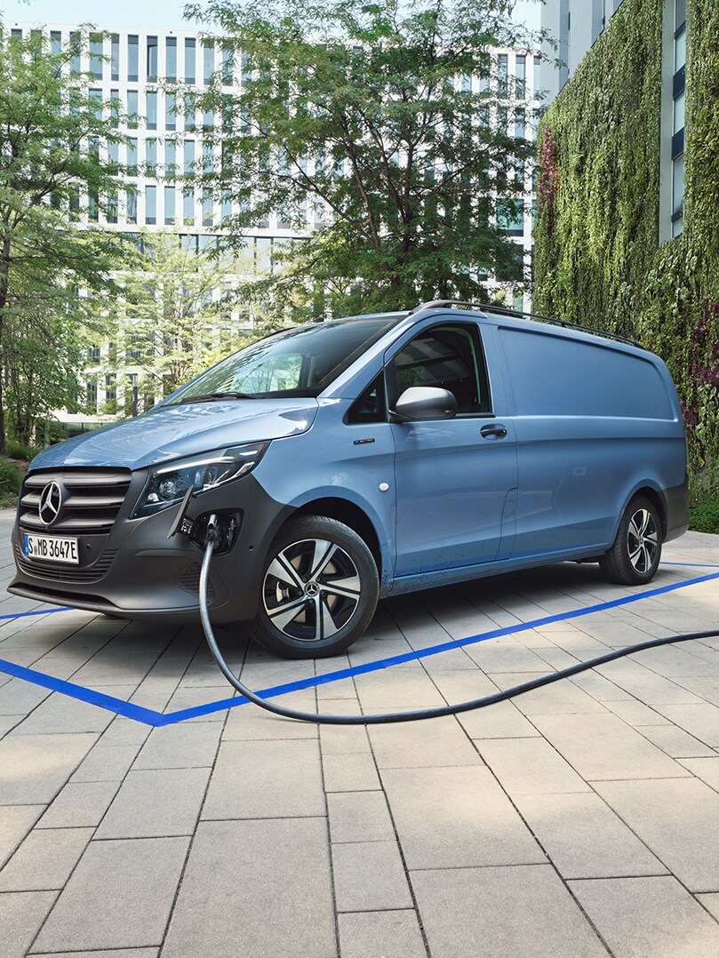 Blå Mercedes-Benz transportbil laddas vid en laddstation