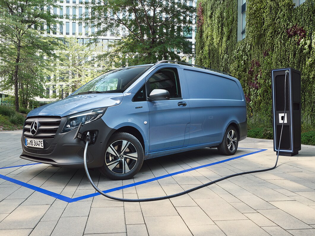 Blå Mercedes-Benz transportbil laddas vid en laddstation