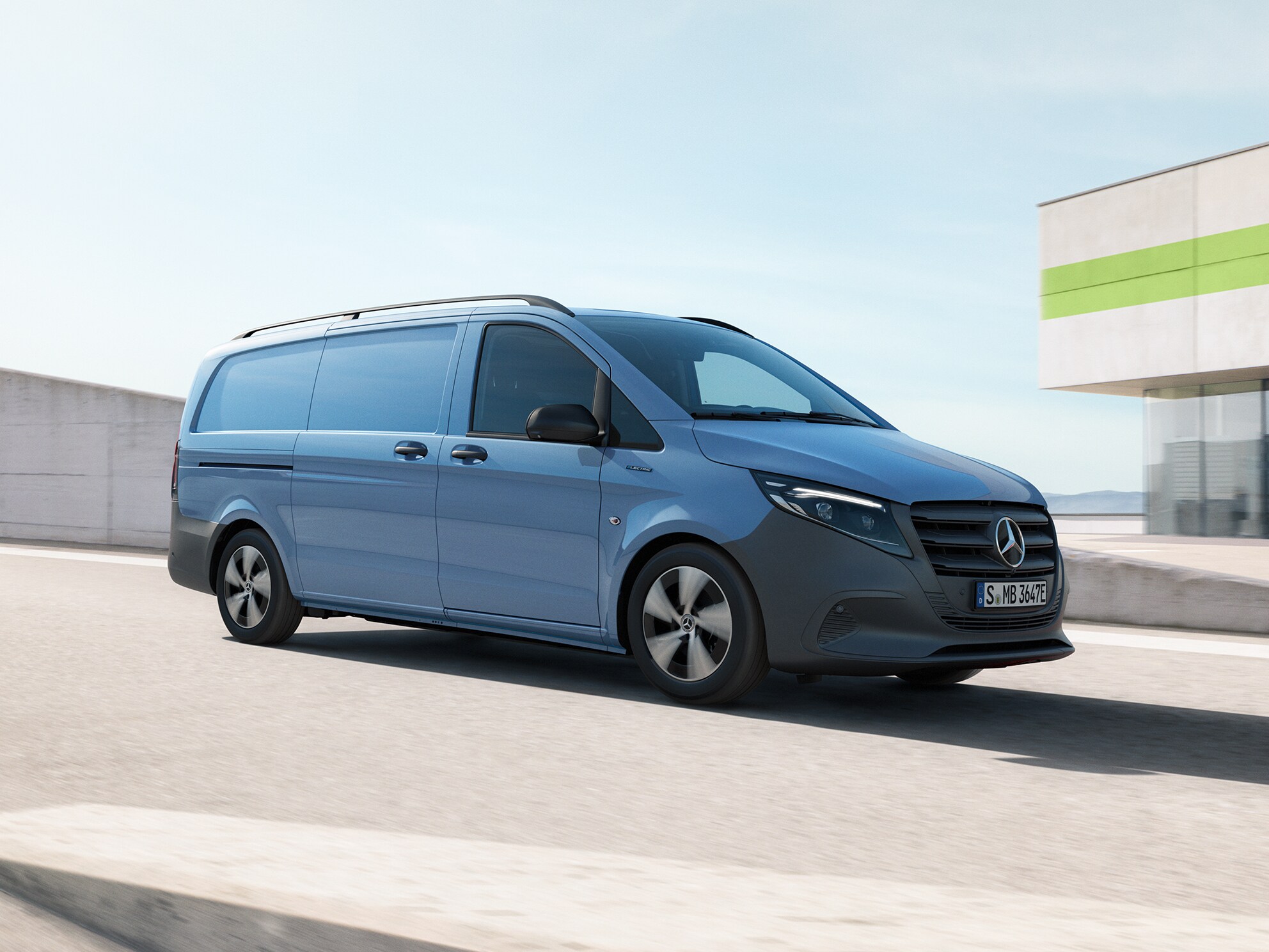 Blå Mercedes-Benz transportbil kör på parkeringsplats ovanpå en byggnad