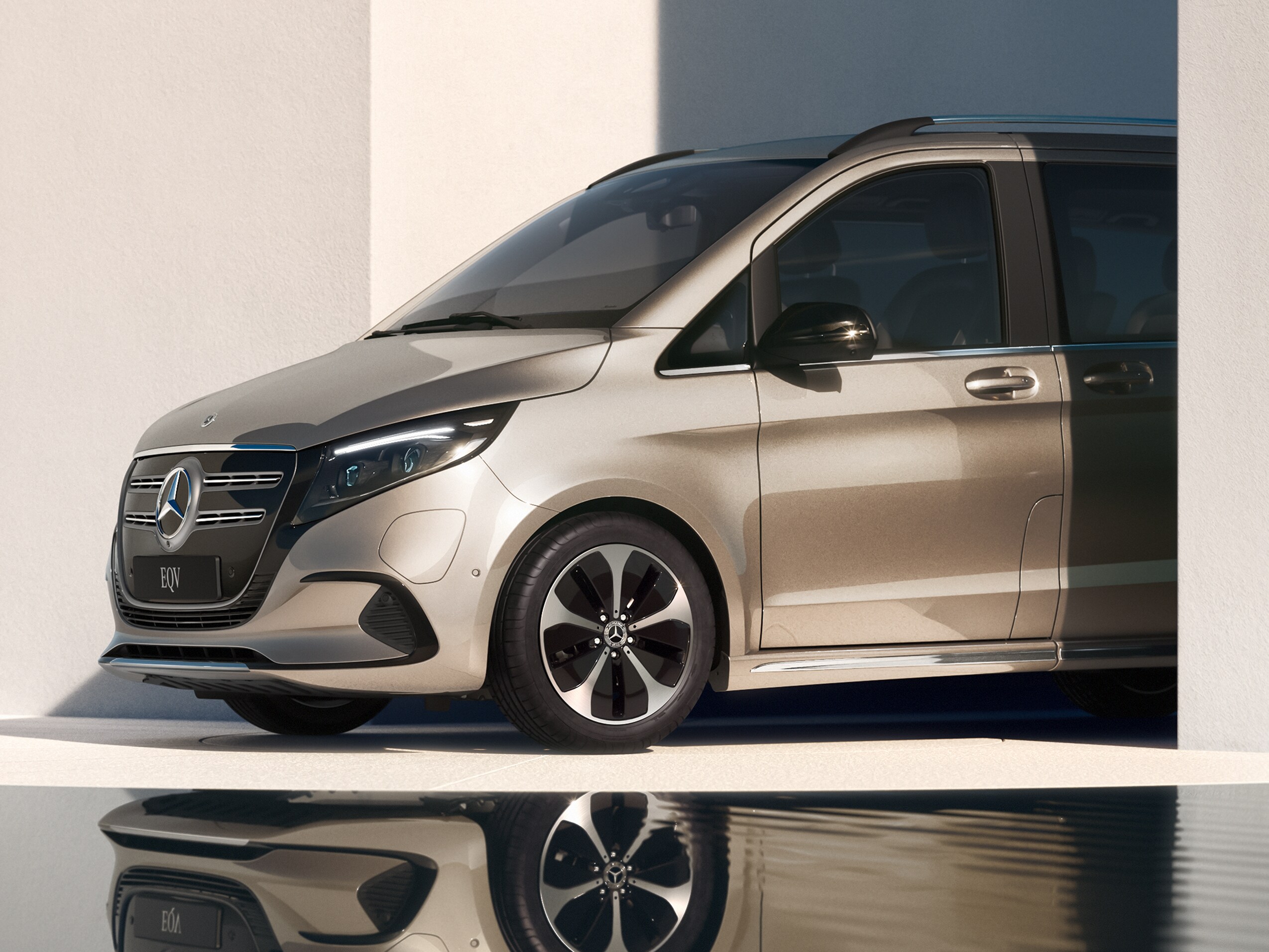 En guldig Mercedes-Benz EQV parkerad framför vatten
