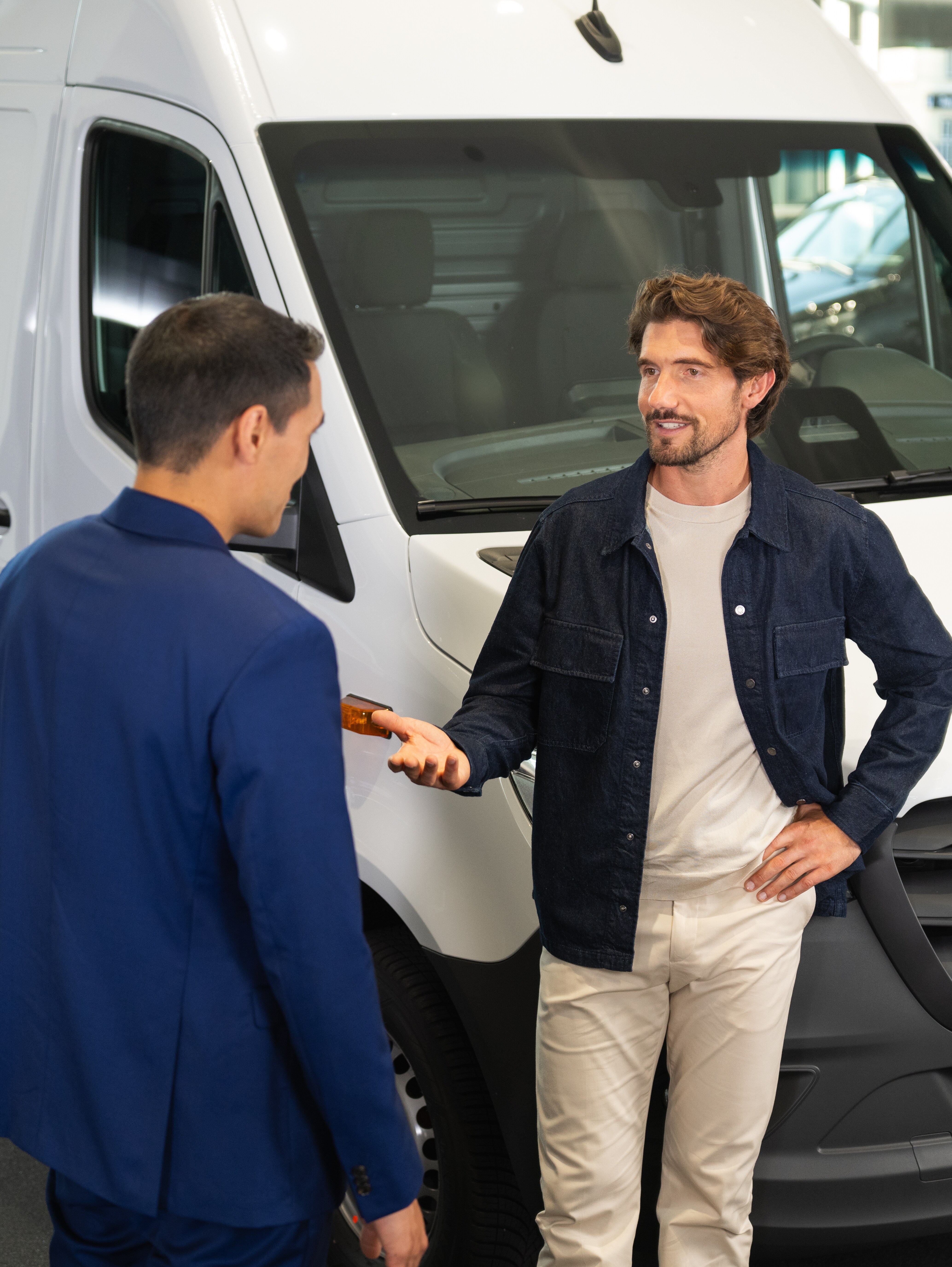 Man pratar med Mercedes-Benz-återförsäljare i showroom.