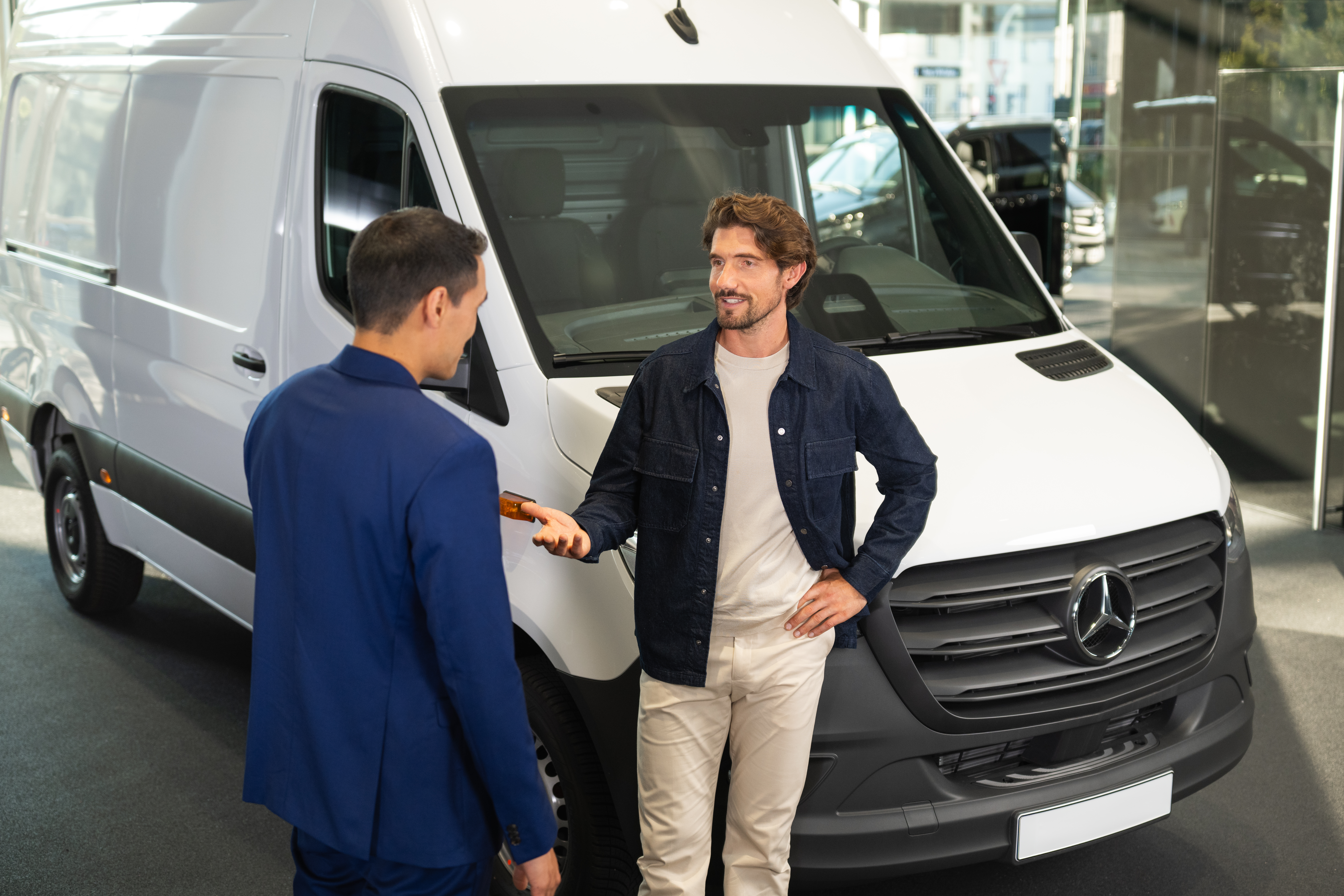Försäkring | Företagsbilar | Mercedes-Benz Transportbilar Man pratar med Mercedes-Benz-återförsäljare i showroom.
