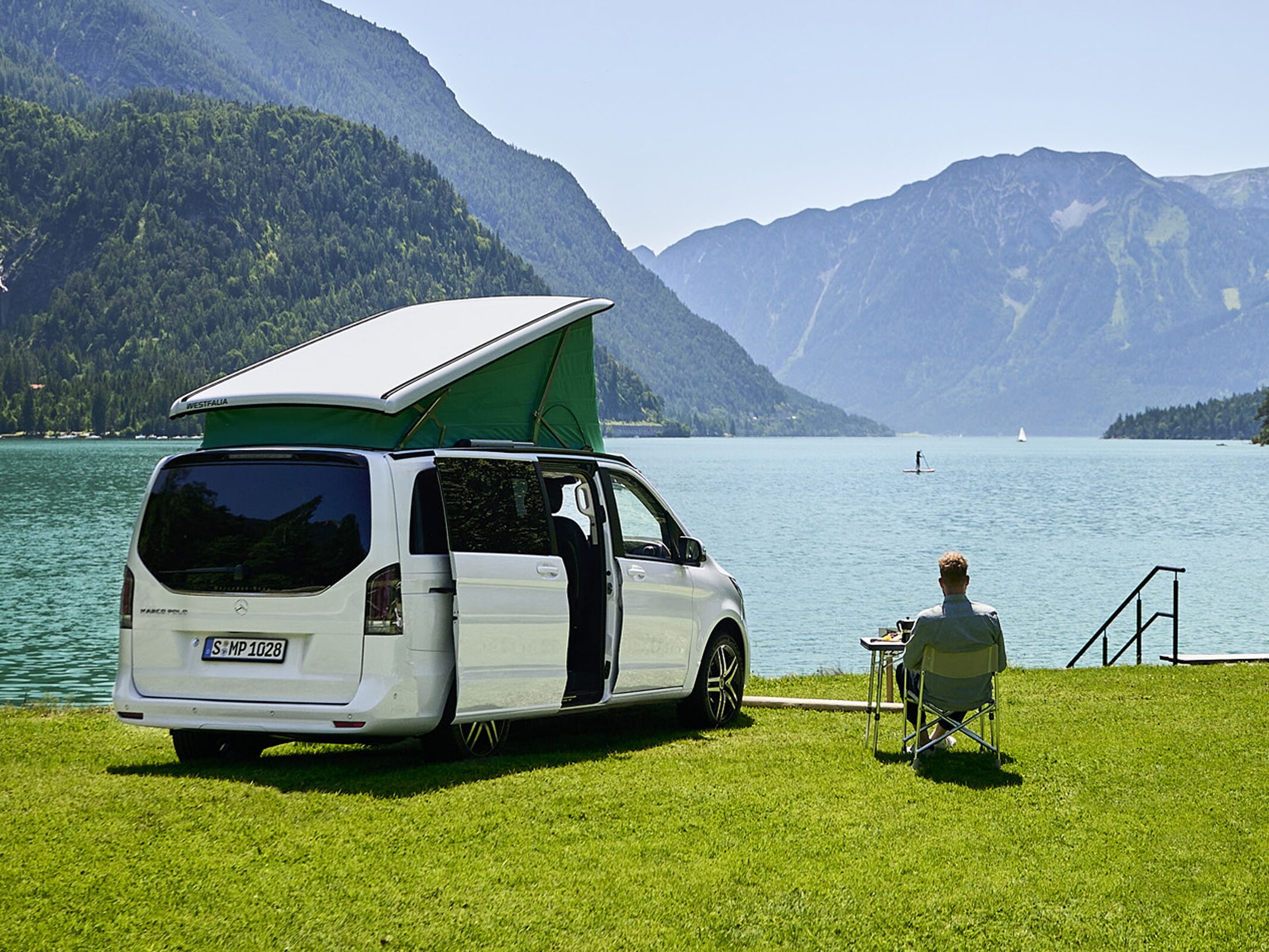 Vit Mercedes-Benz Marco Polo med uppfällt pop-up tak vid sjöstranden